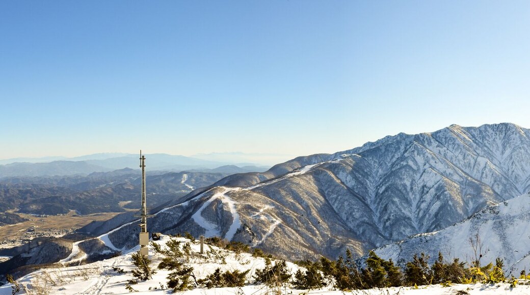Hakuba mountain range on a clear sunny day. The very steep mountain area is between two ski resorts, Happo-One and Goryu. A natural flat area between the ranges is inhabited by the local villagers.; S