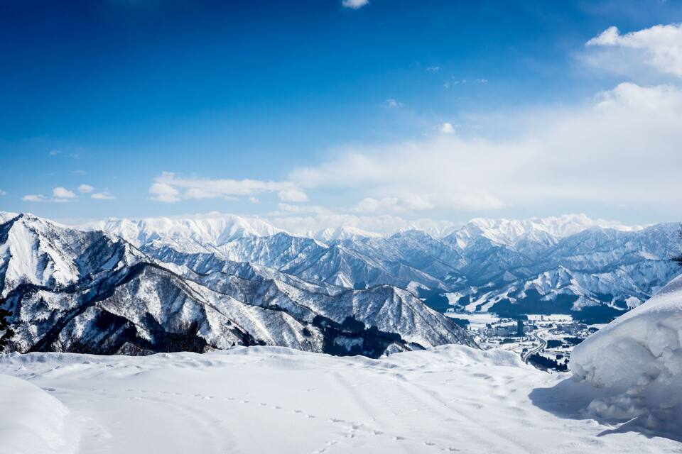 Cordilheira coberta de neve com céu azul límpido.