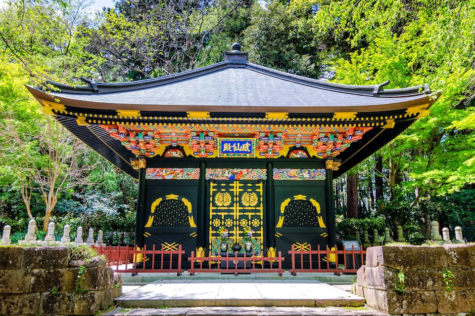 A traditional Japanese temple with ornate decorations and a red fence.