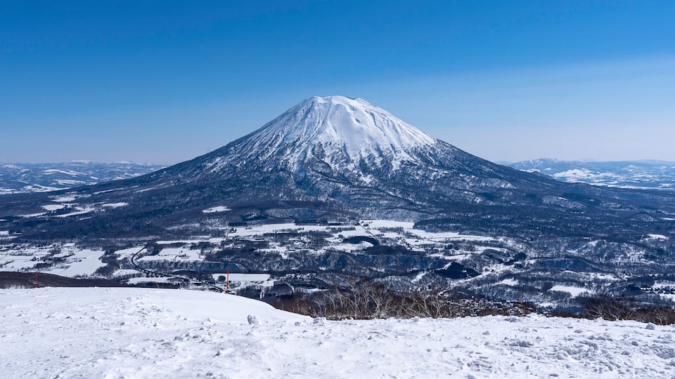 A snow-covered mountain with a clear sky.