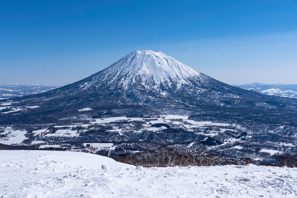 A snow-covered mountain with a clear sky.