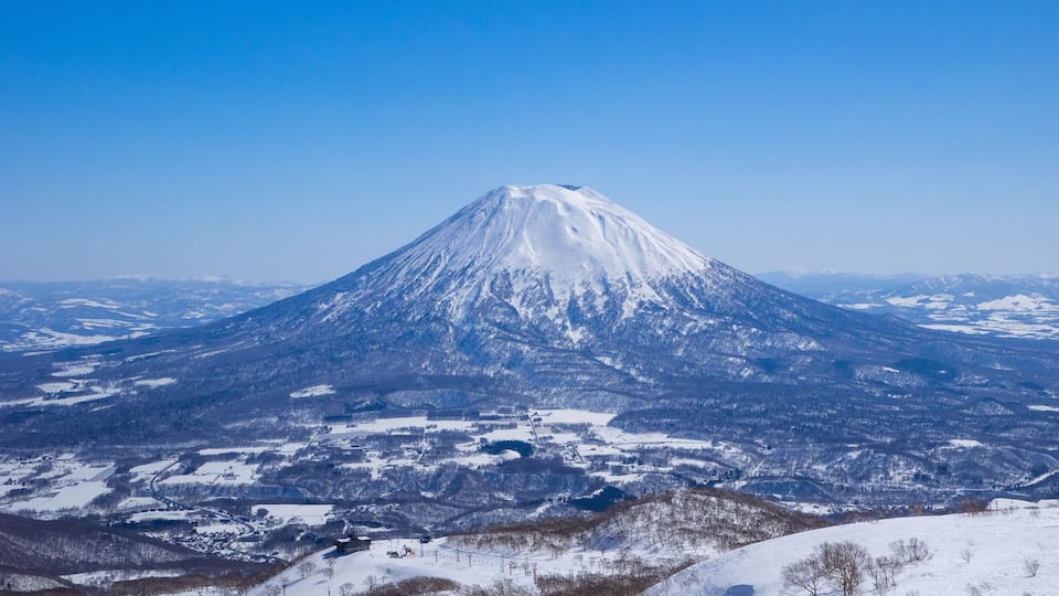 A snow-covered mountain with a clear sky.