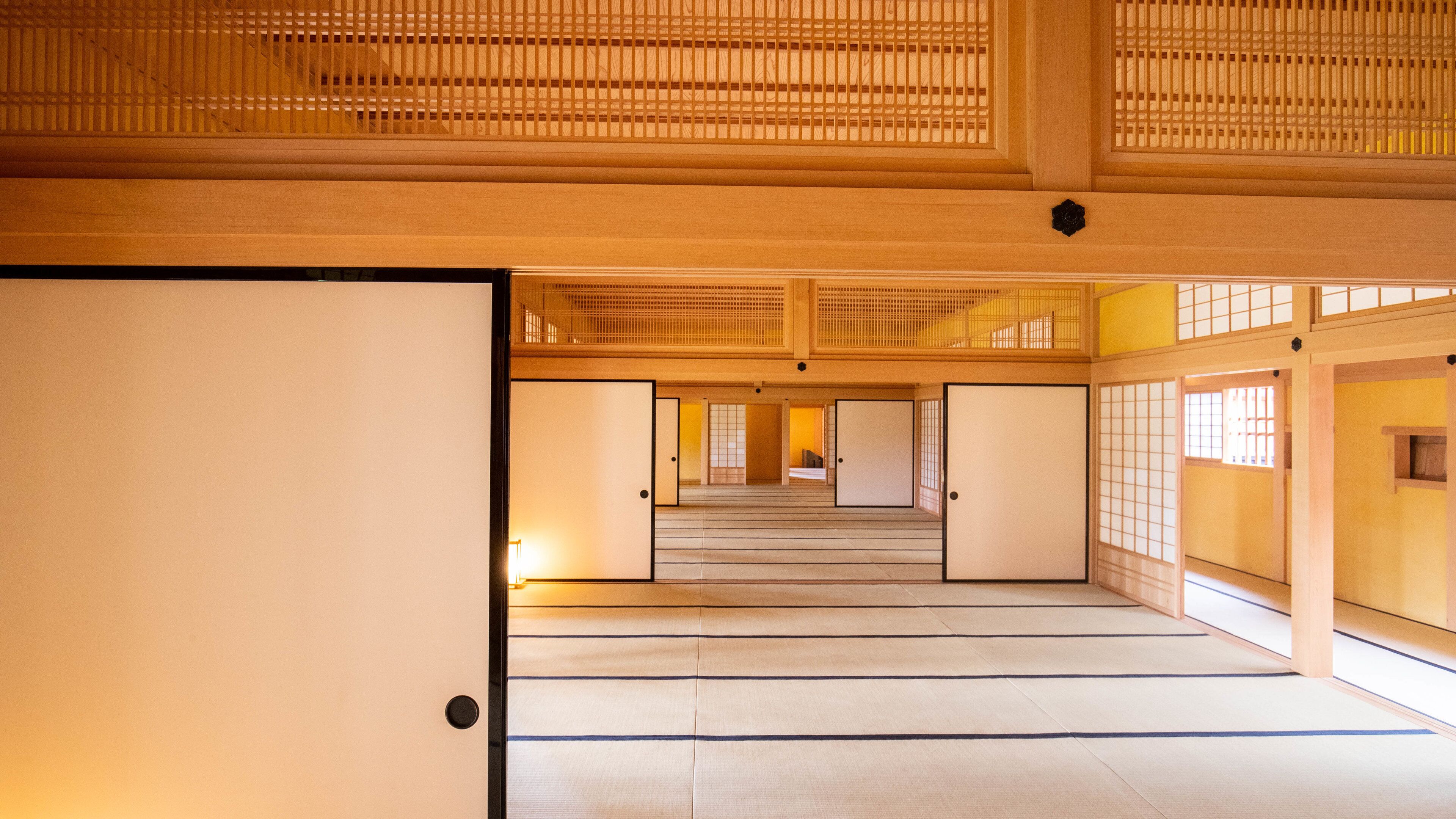 A traditional Japanese interior with tatami flooring, sliding doors, and shoji screens.
