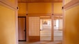 A traditional Japanese interior with wooden beams, tatami flooring, and sliding doors.