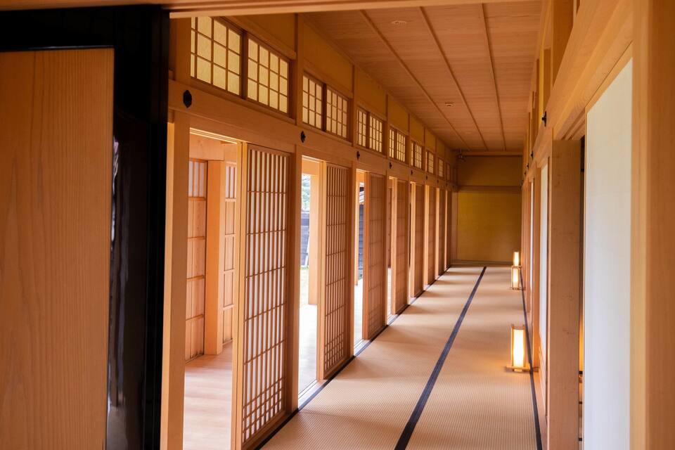 Un pasillo japonés tradicional con suelo de tatami y puertas correderas.