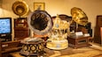 A collection of antique gramophones and record players on a wooden table.