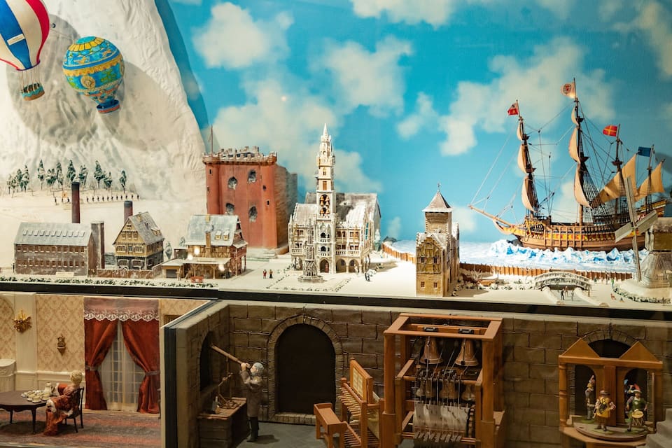 A detailed model of a historical town with a church, a castle, and a sailing ship.