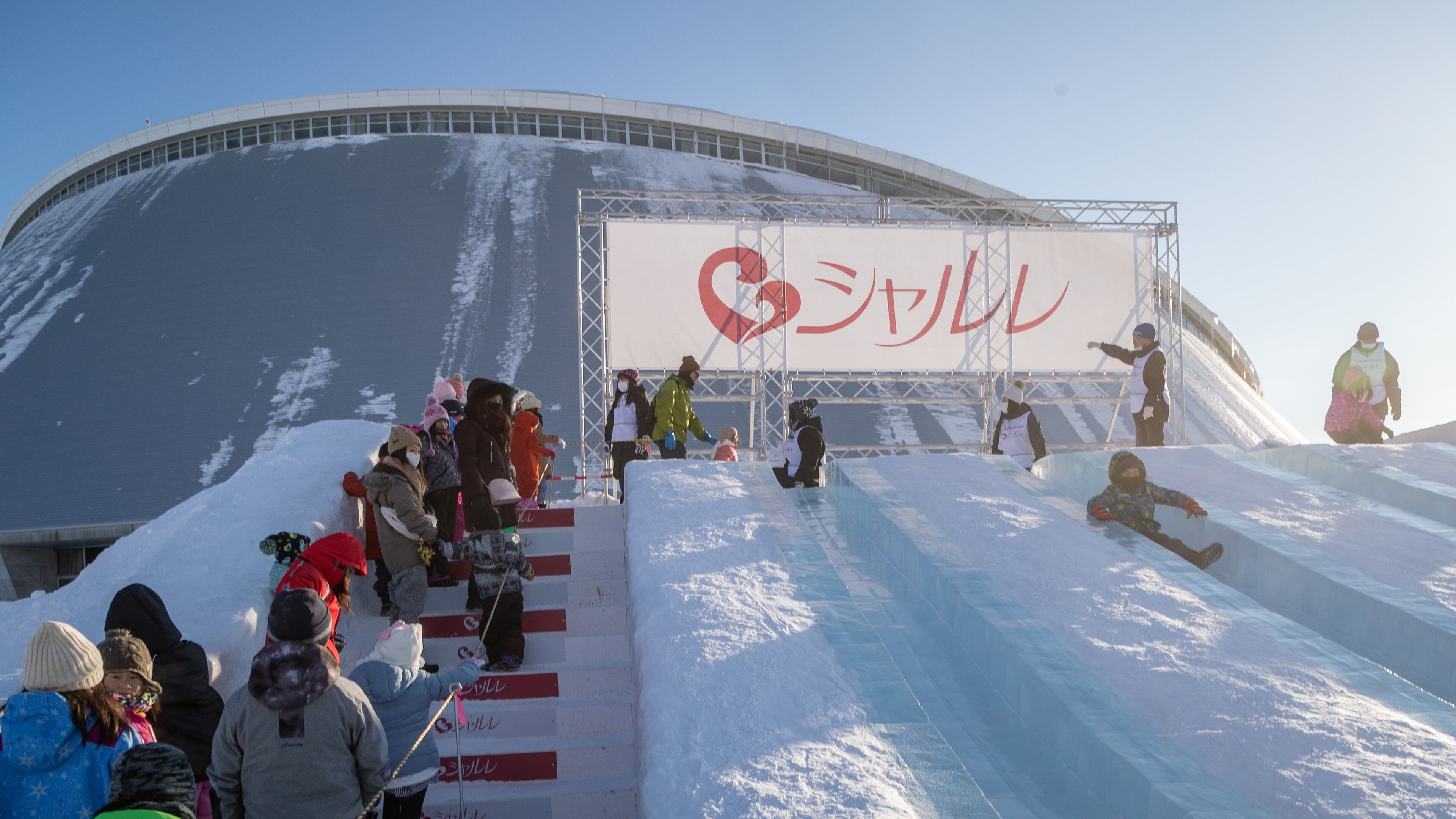 Sapporo Community Dome which includes signage and snow as well as a large group of people