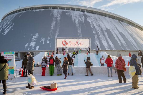 Sapporo Community Dome which includes snow, a sunset and signage