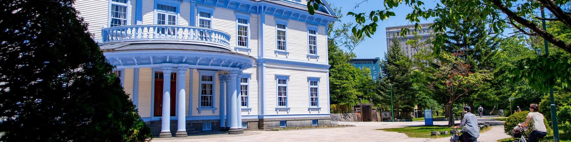 A historic blue building with a white balcony and a clock tower.