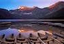 Row boats moored at pier on Cameron Lake, alpenglow on mountains