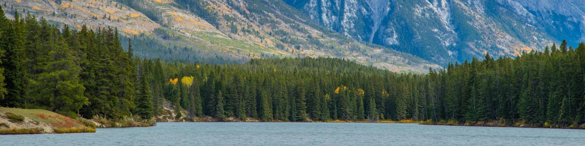 Minnewanka Loop / Lake Johnson featuring mountains and a lake or waterhole