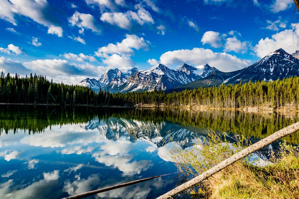 A mountain lake with reflections of the sky and mountains.