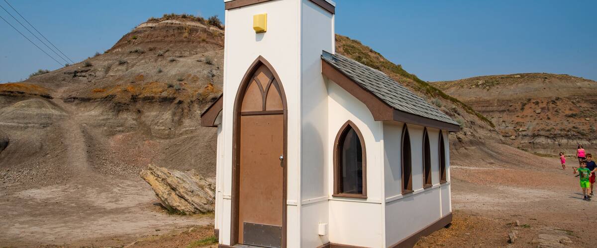Drumheller\'s Little Church showing desert views, a church or cathedral and farmland