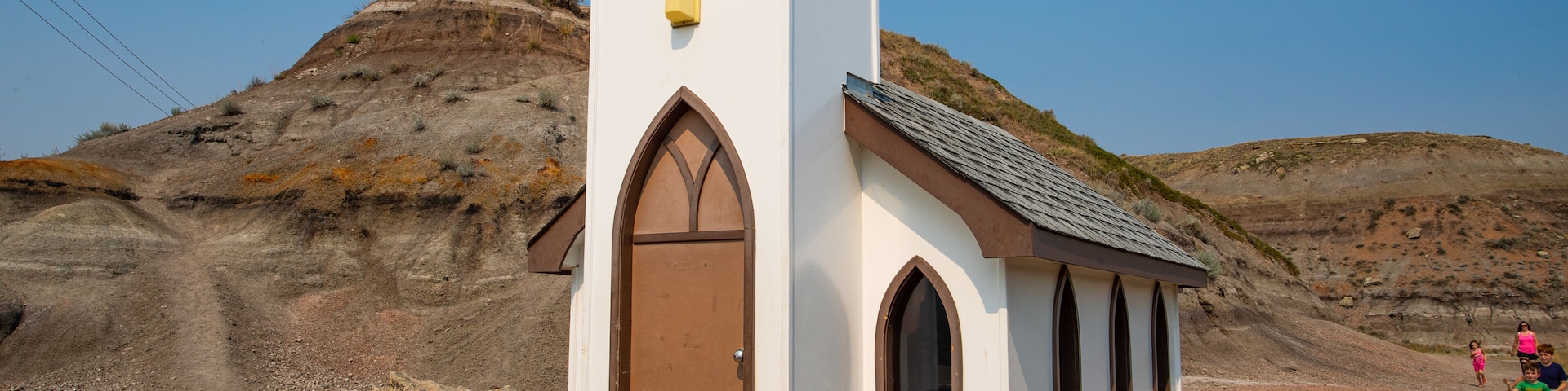 Drumheller\'s Little Church showing desert views, a church or cathedral and farmland