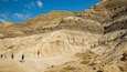 Drumheller Hoodoos featuring a gorge or canyon and mountains as well as a small group of people