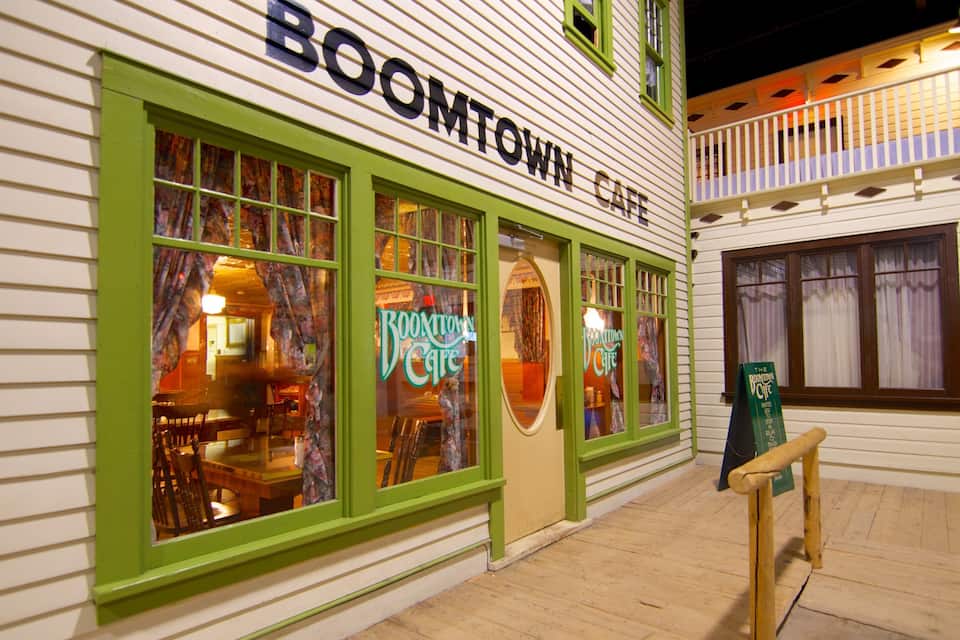 A building with green-framed windows and a sign reading "BOOMTOWN CAFE".