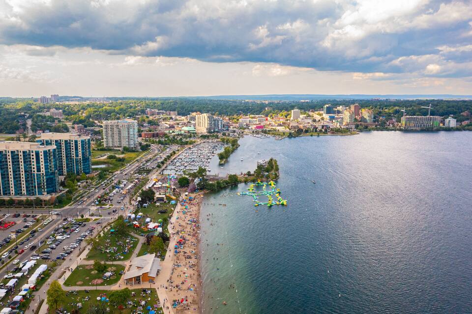 A coastal cityscape with a marina, beach, and high-rise buildings.