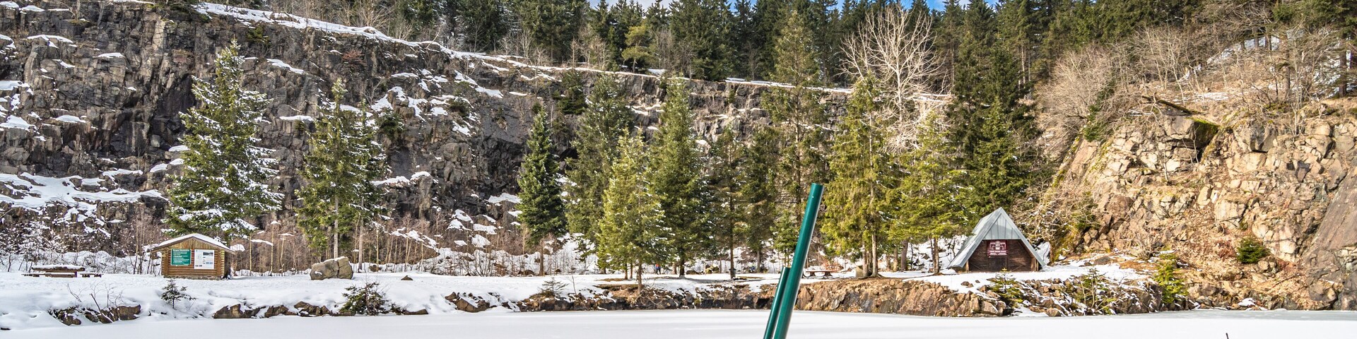 Winterlandschaft mit zugefrorenem See und Leiter