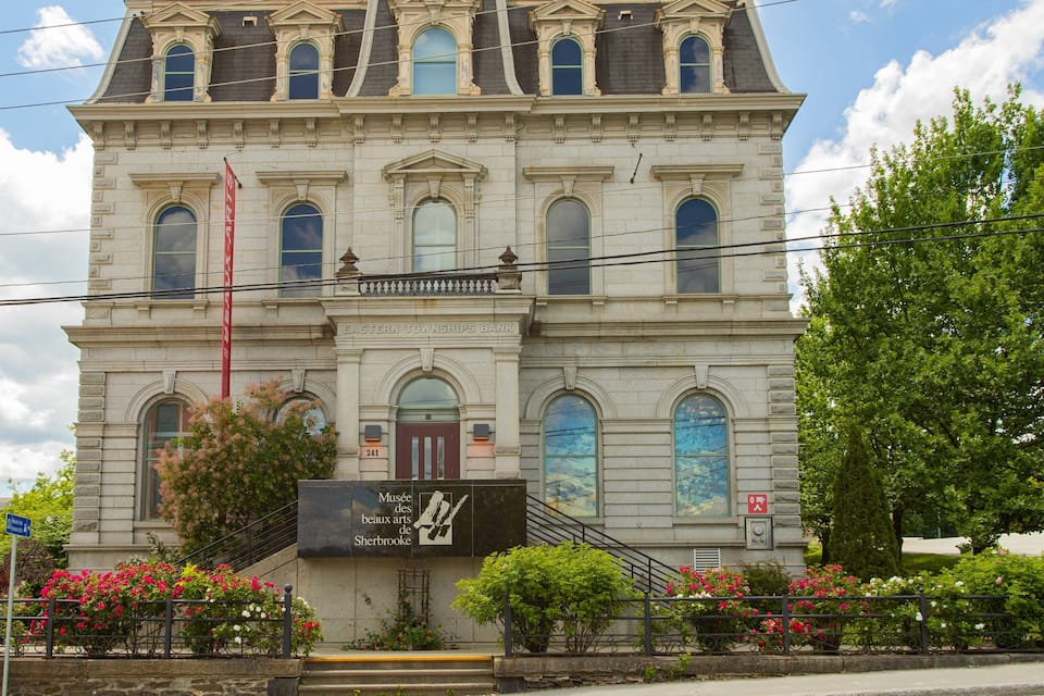 A historic building with a sign for the Eastern Townships Bank and a museum.