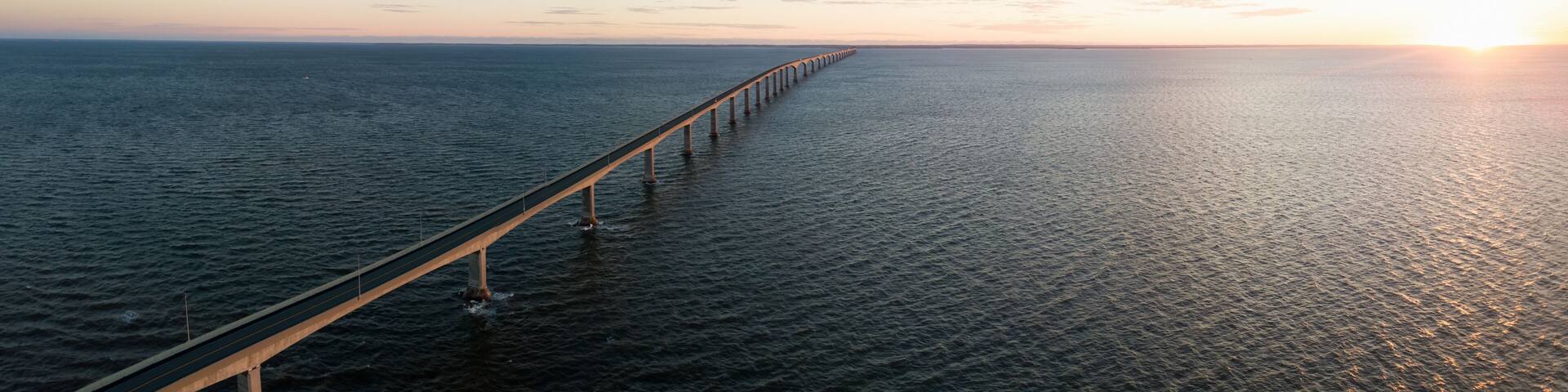 Aerial Panoramic view of Confederation Bridge to Prince Edward Island during a vibrant sunny sunrise. Taken in Cape Jourimain National Wildlife Area, New Brunswick, Canada.