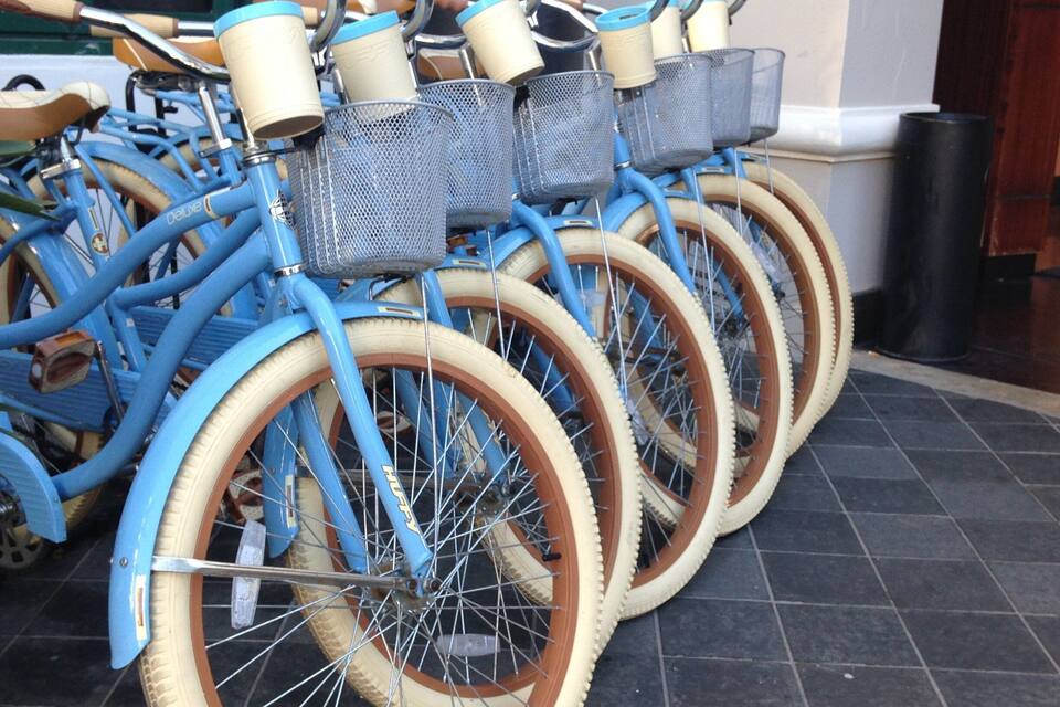 Blå cykler med fletkurve og brune dæk parkeret på et flisegulv.