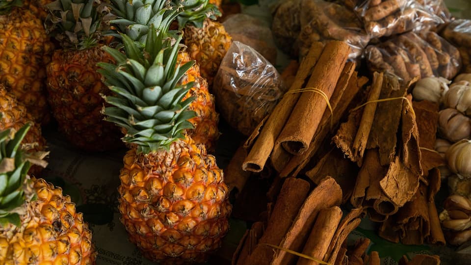 Pineapples, cinnamon sticks, and garlic cloves.