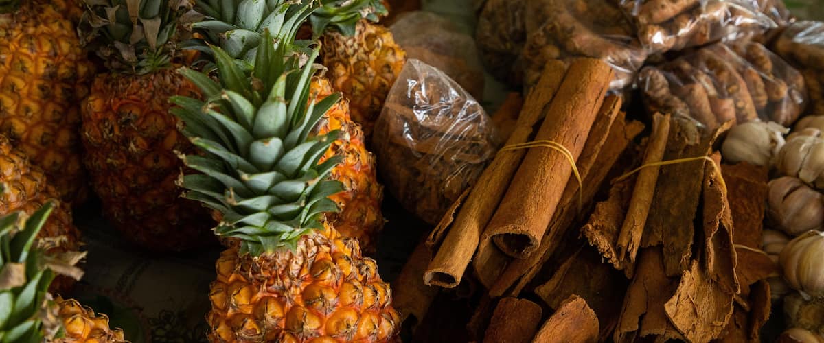 Pineapples, cinnamon sticks, and garlic cloves.