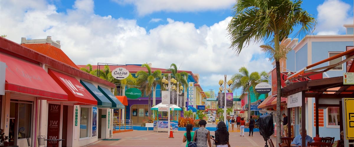 A bustling street with shops, a casino, and palm trees.