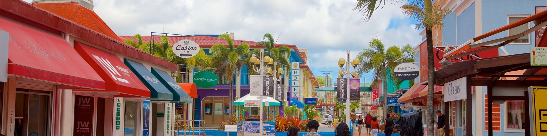 Una calle concurrida con tiendas, un casino y palmeras.