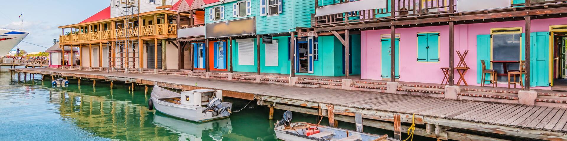A waterfront with colorful buildings, a dock, and a small boat.