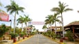A street lined with palm trees and a sign for a restaurant.