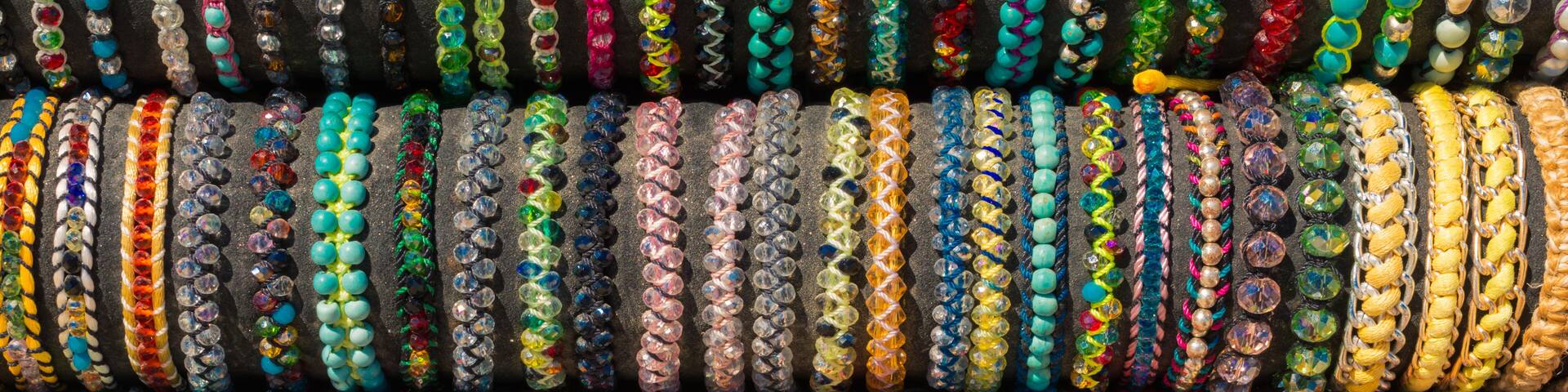 Una variedad de pulseras coloridas con diferentes diseños y motivos.