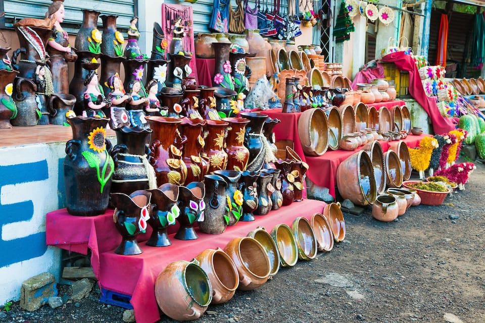 A variety of colorful pottery displayed on tables and shelves.