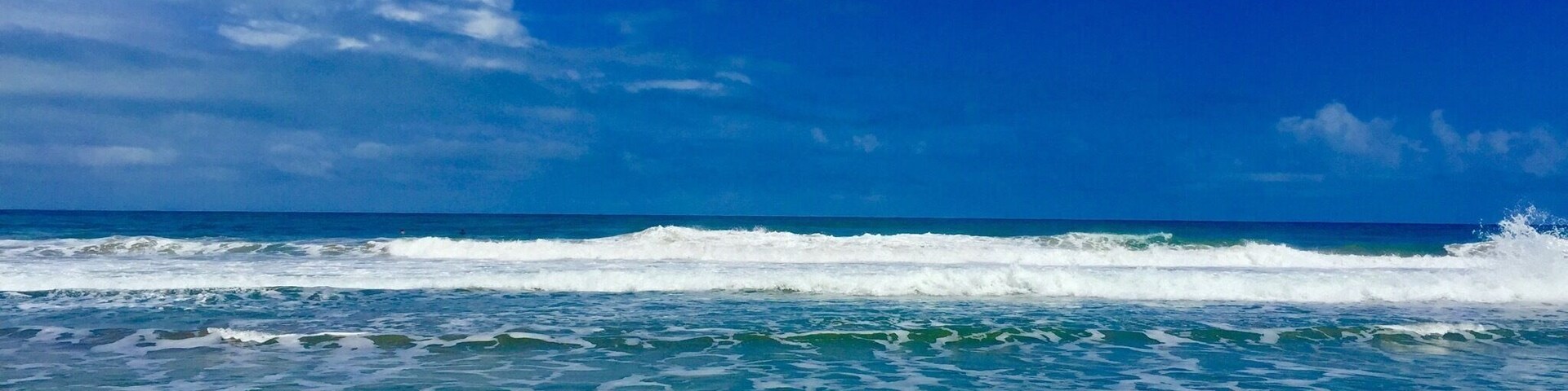 Uma praia com águas azul-claras e ondas.