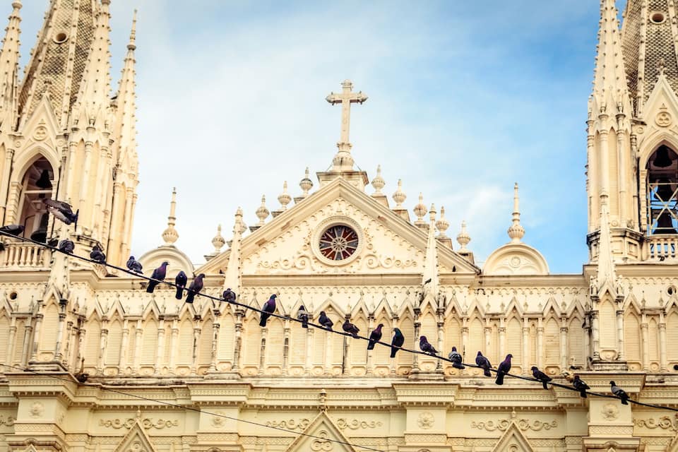 Una catedral de estilo gótico con imponentes agujas y una cruz destacada.