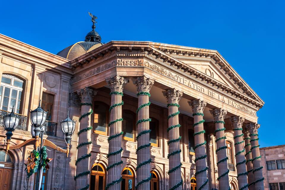 Un bâtiment historique doté de colonnes richement décorées et d’un dôme, sur lequel l’année « 1889 » est clairement visible.