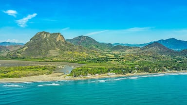 A coastal landscape with mountains, a beach, and a river.