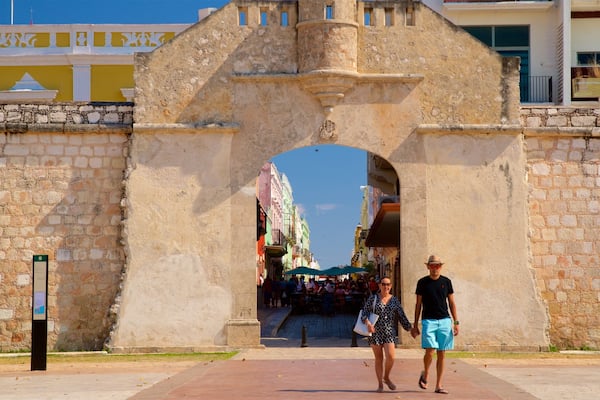 An old stone archway with people walking through it.