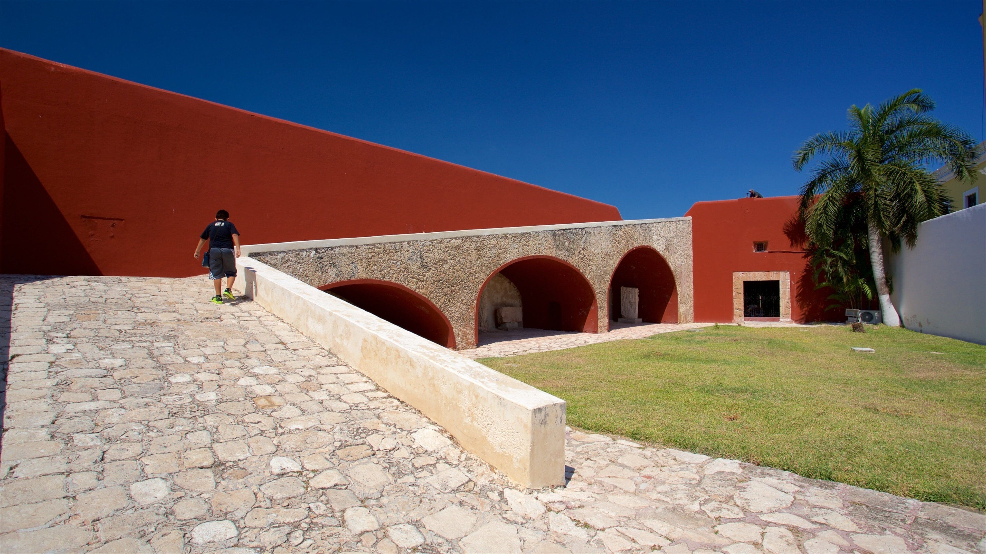 Museum for maya-arkitektur som inkluderer hage i tillegg til en mann