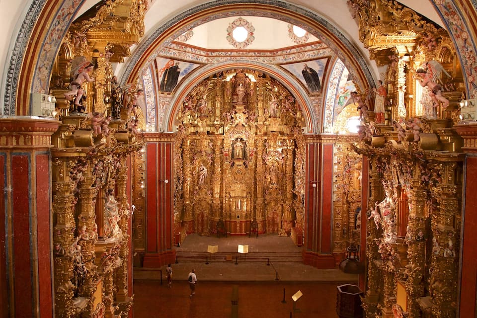 Ein prächtiges Kircheninnere mit goldenen Verzierungen und Statuen.