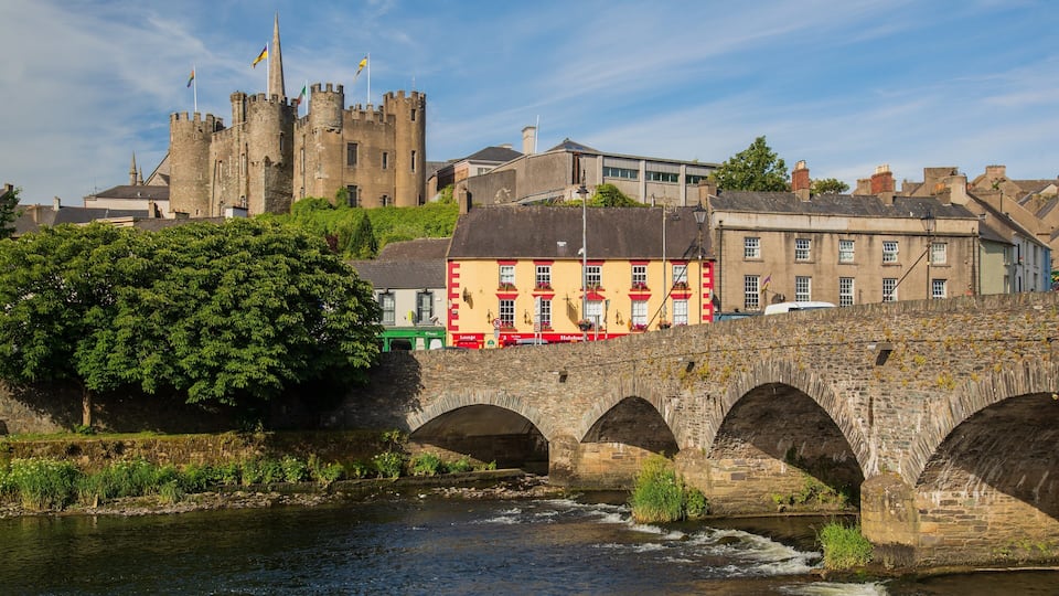 A stone bridge over a river, a castle, and a colorful building with a sign that says "Lounge."