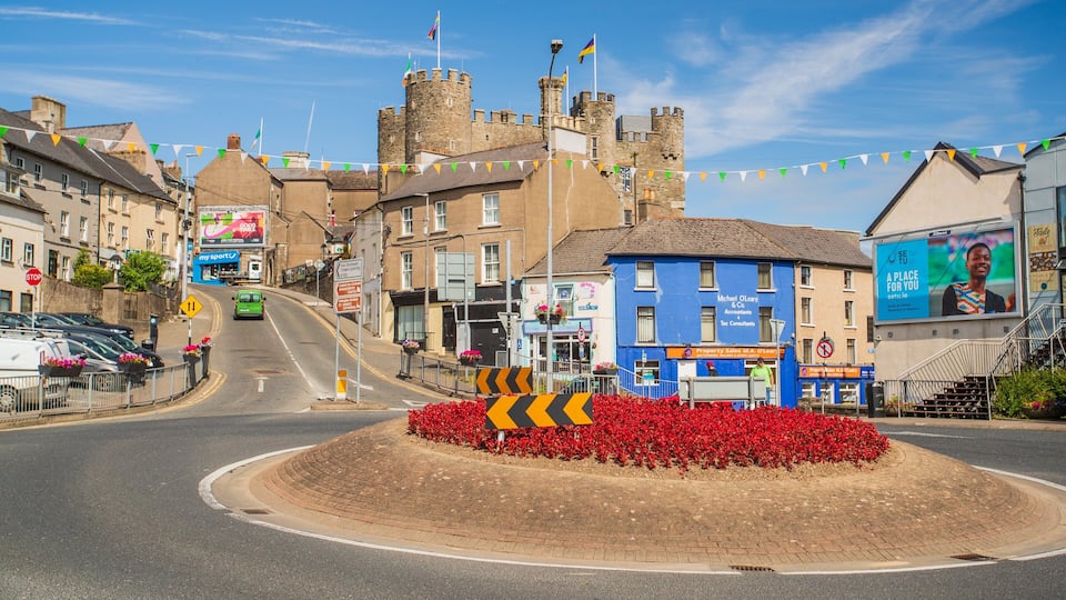 A town square with a roundabout, a castle, and colorful flags.