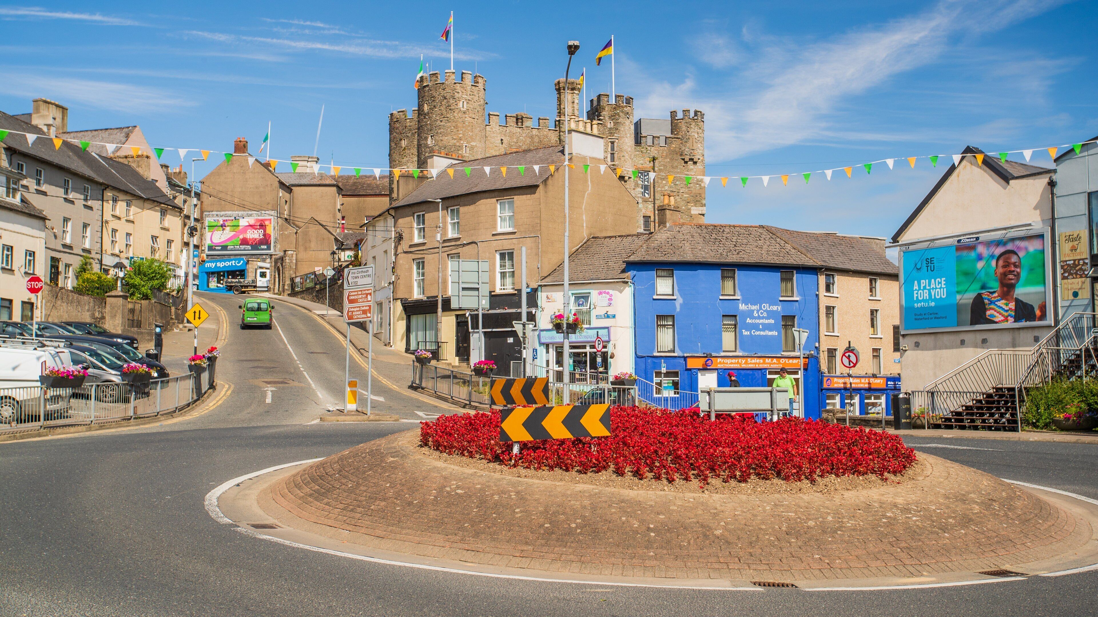 A town square with a roundabout, a castle, and colorful flags.