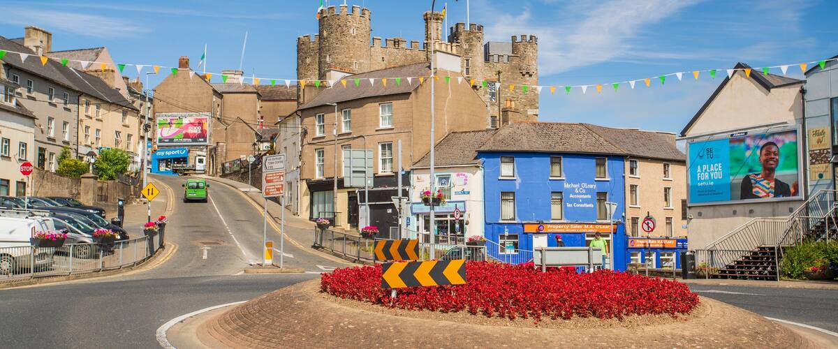 A town square with a roundabout, a castle, and colorful flags.