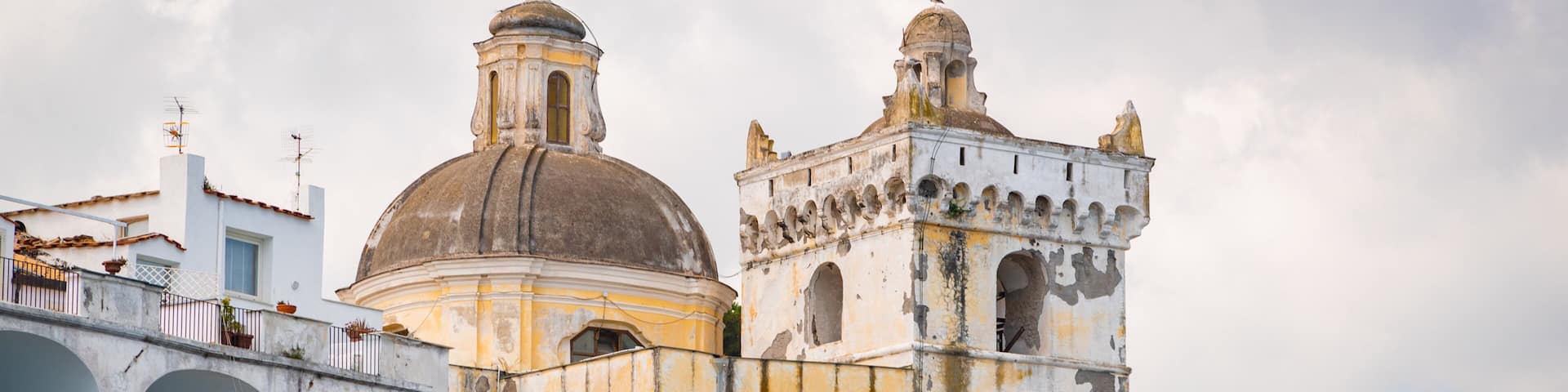 A historic church with a dome and bell tower, surrounded by white buildings with arches.