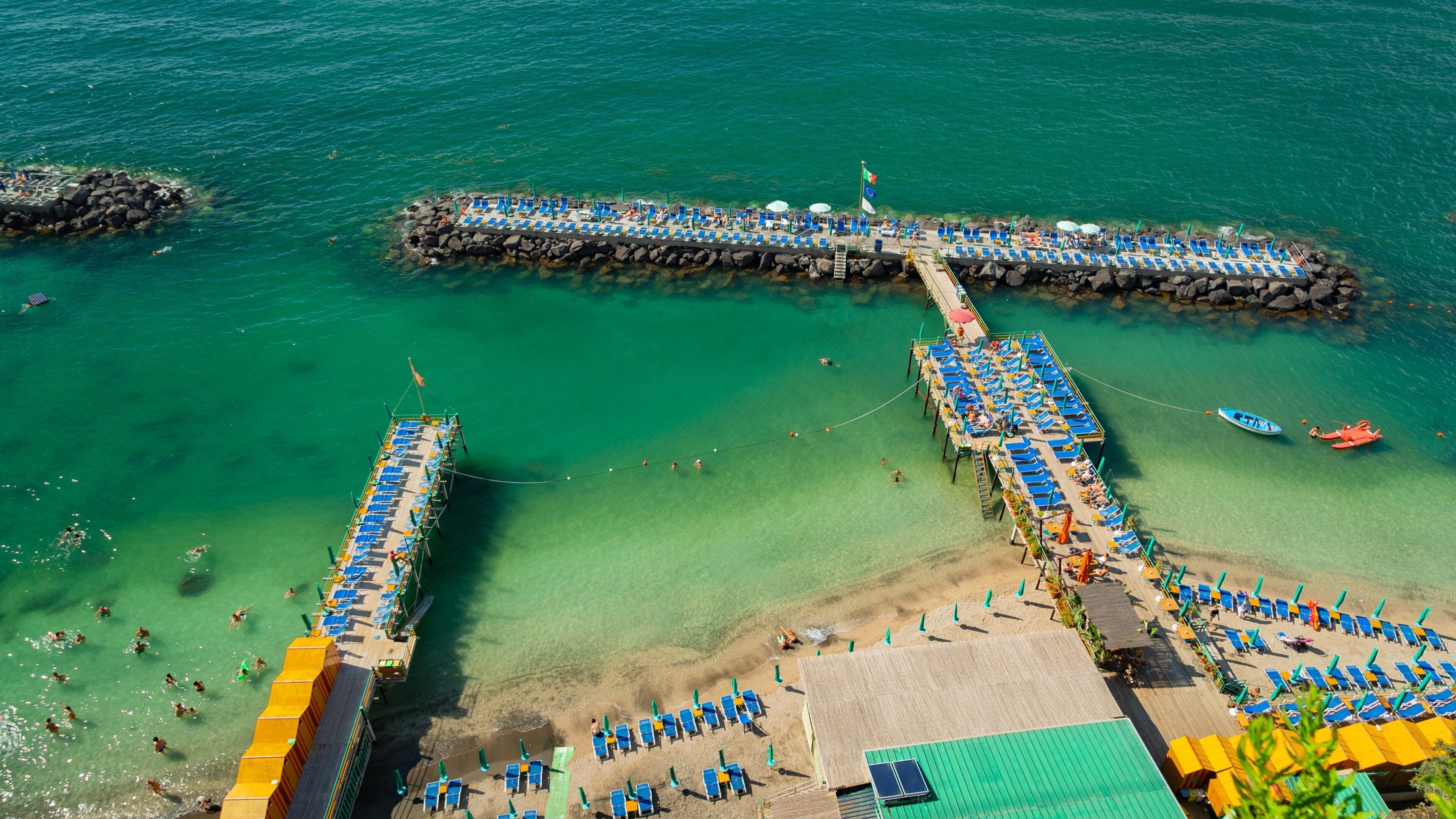 Villa Comunale Park showing general coastal views and swimming as well as a small group of people