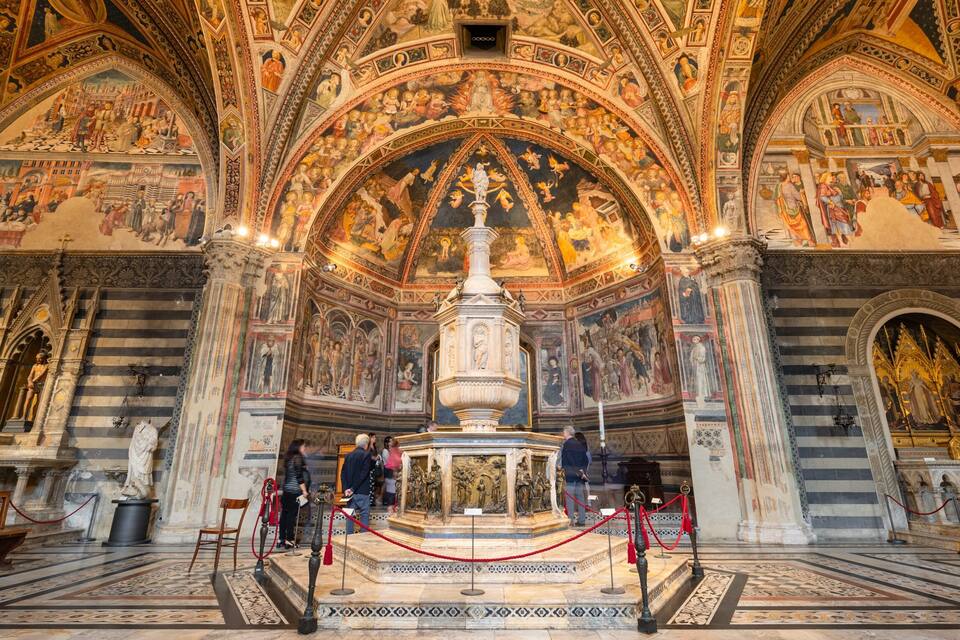 Majestätische Kathedralkirche mit aufwendigen Fresken, einem prunkvollen Altar im Zentrum und Besuchern, die die Kunstwerke betrachten.