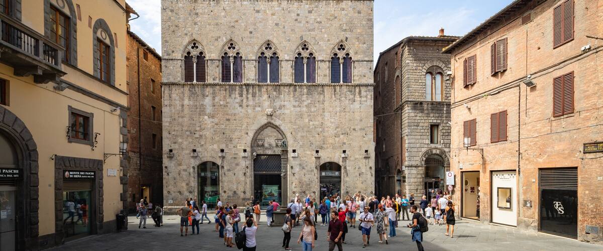 Palazzo Tolomei showing heritage architecture and street scenes as well as a small group of people