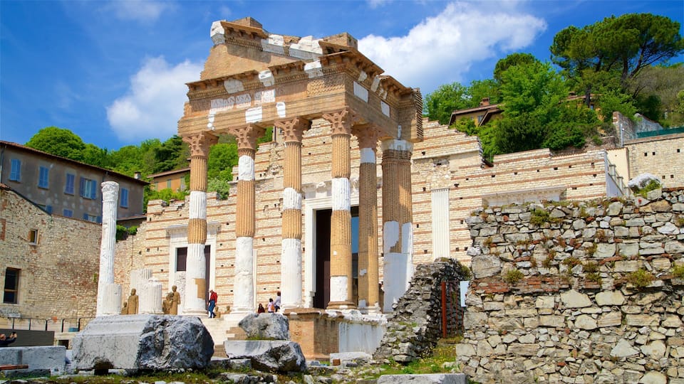 Ancient ruins with columns and a stone wall.
